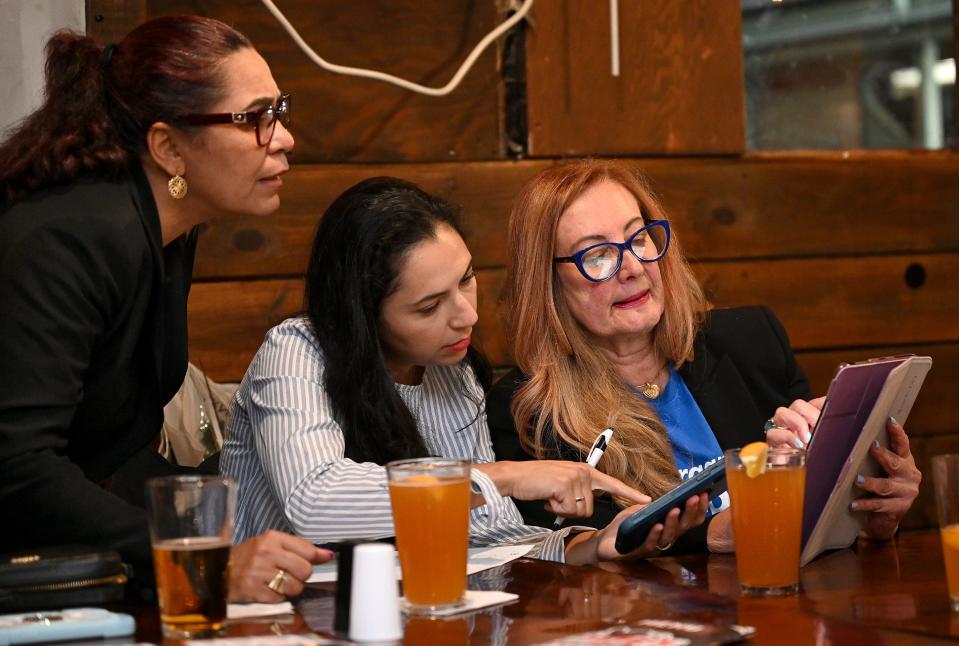 Margareth Shepard, right, tallies election results with supporters Jessica Da Silva, center, and Vera Quintao at the Route 9 Sports Bar in Framingham, Sept. 6, 2022.