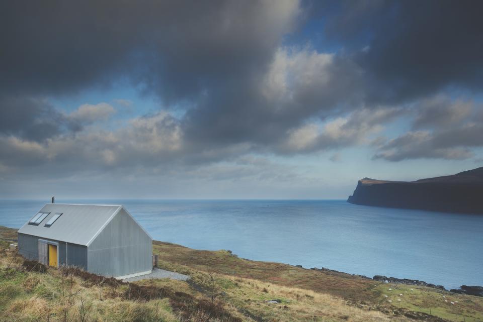 Clad in corrugated metal, Tinhouse is a contemporary retreat on the Isle of Skye that was built by architects Gill Smith and Alan Dickson. They incorporated a color palette inspired by the surrounding landscape and used materials, such as concrete and plywood, that lend to the handmade look.