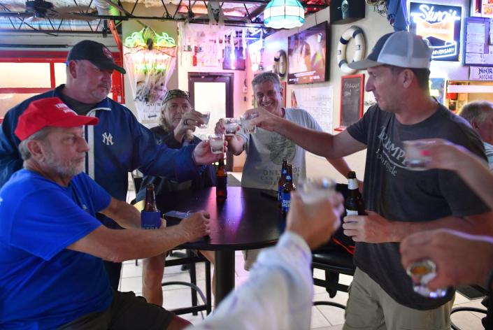 Customers at Salty Jim's Island Bar &amp; Grill make a toast to Hurricane Ian Wednesday afternoon, Sept. 28, 2022.  The bar, at Beneva Rd. and Webber St. in Sarasota, Florida, plans to stay open as long as they can. 
