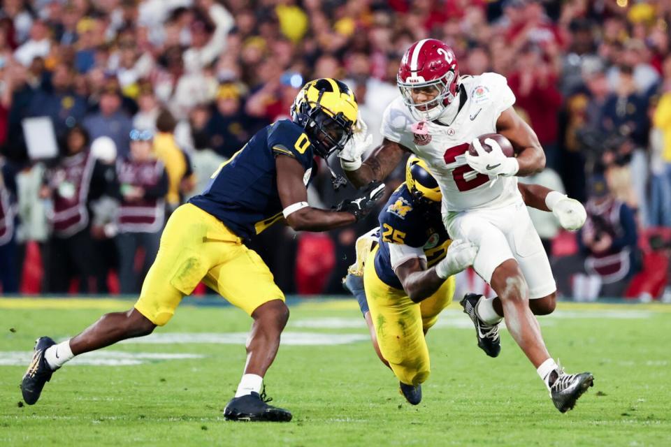 Alabama tailback Jase McClellan runs the ball under pressure from Michigan's Junior Colson and back Will Johnson