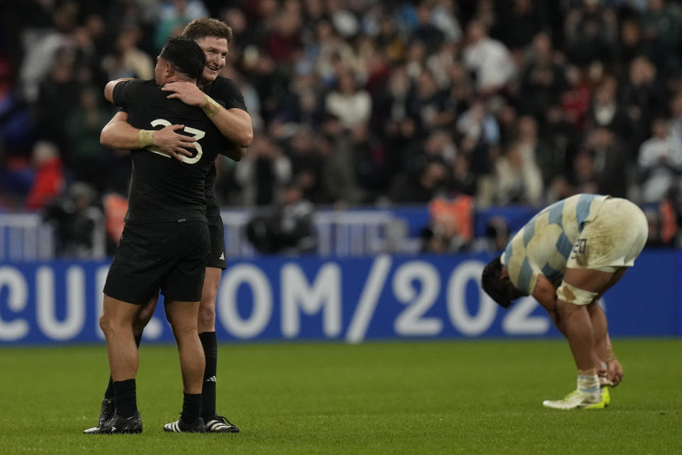 New Zealand's Jordie Barrett and New Zealand's Anton Lienert-Brown, left, hug after the Rugby World Cup semifinal match between Argentina and New Zealand at the Stade de France in Saint-Denis, outside Paris, Friday, Oct.20, 2023. (AP Photo/Thibault Camus)