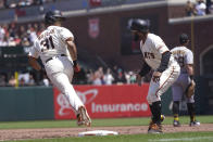 San Francisco Giants' LaMonte Wade Jr, left, reacts toward first base coach Antoan Richardson after hitting a home run against the Pittsburgh Pirates during the third inning of a baseball game in San Francisco, Sunday, July 25, 2021. (AP Photo/Jeff Chiu)