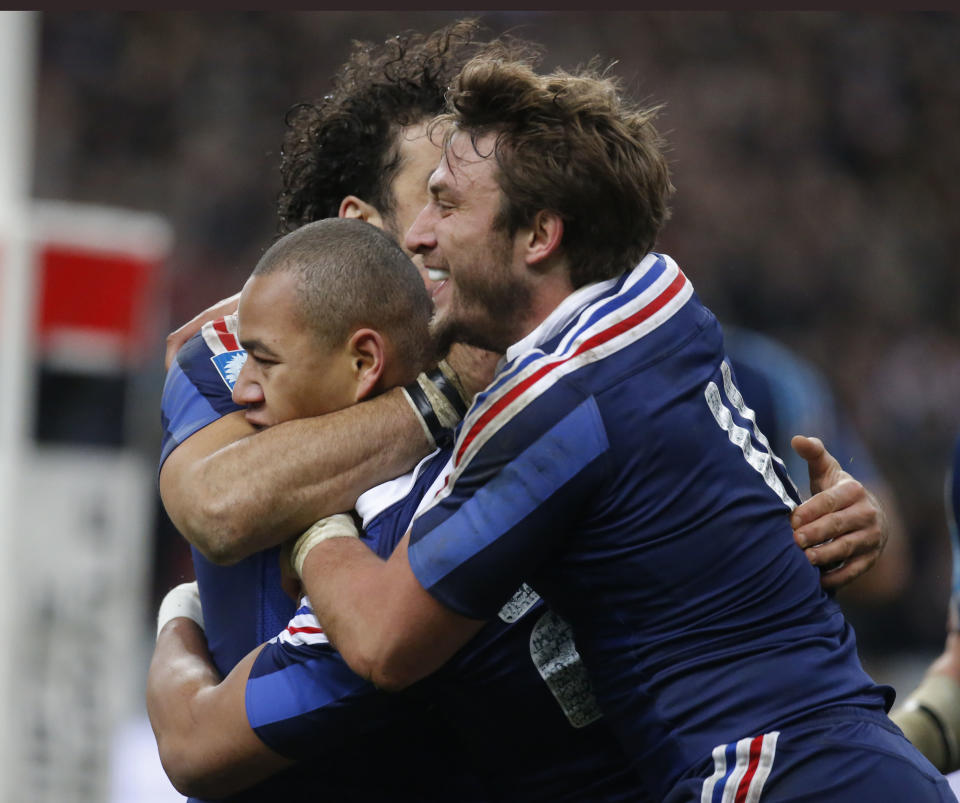 France's Gael Fickou, center, is congratulated by his teammates, Yoann Huget, left, and Maxime Medard after he scored the winning try during a Six Nations international rugby union match between France and England at Stade de France stadium in Saint Denis, near Paris, Saturday, Feb. 1, 2014. France beat England 26 -24(AP Photo/Michel Euler)