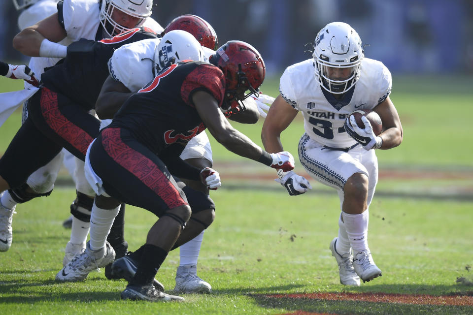 San Diego State safety C.J. Baskerville (34) tackles Utah State running back Elelyon Noa (34) in the first half during an NCAA college football game for the Mountain West Conference Championship, Saturday, Dec. 4, 2021, in Carson, Calif. (AP Photo/John McCoy)