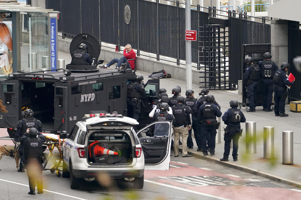 NYPD emergency services officers respond to a man standing outside United Nations headquarters with a shotgun, Thursday, Dec. 2, 2021, in New York. Hostage negotiators spoke to the man who appeared to be in his 60s, and hoped to resolve the situation peacefully. (AP Photo/John Minchillo)