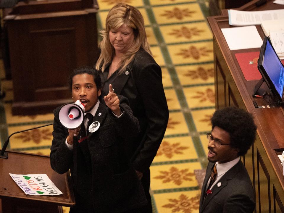 Tennessee State Representative Justin Jones, standing with Rep. Justin Pearson and Rep. Gloria Johnson, calls on his colleagues to pass gun control legislation from the well of the House Chambers during the legislative session