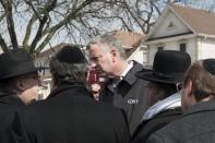 New York Mayor Bill de Blasio (C) speaks to community members after arriving to the site of a home fire in the Midwood neighborhood of Brooklyn, New York March 21, 2015. In one of New York City's deadliest fires in years, seven children from the same Orthodox Jewish family died early on Saturday when flames ripped through their Brooklyn home, officials said. The blaze, which erupted just before 12:30 a.m. (0430 GMT), appeared to have been started accidentally by a hot plate, which are used by many Orthodox families to warm food on the Sabbath, said Fire Commissioner Daniel Nigro. REUTERS/Stephanie Keith