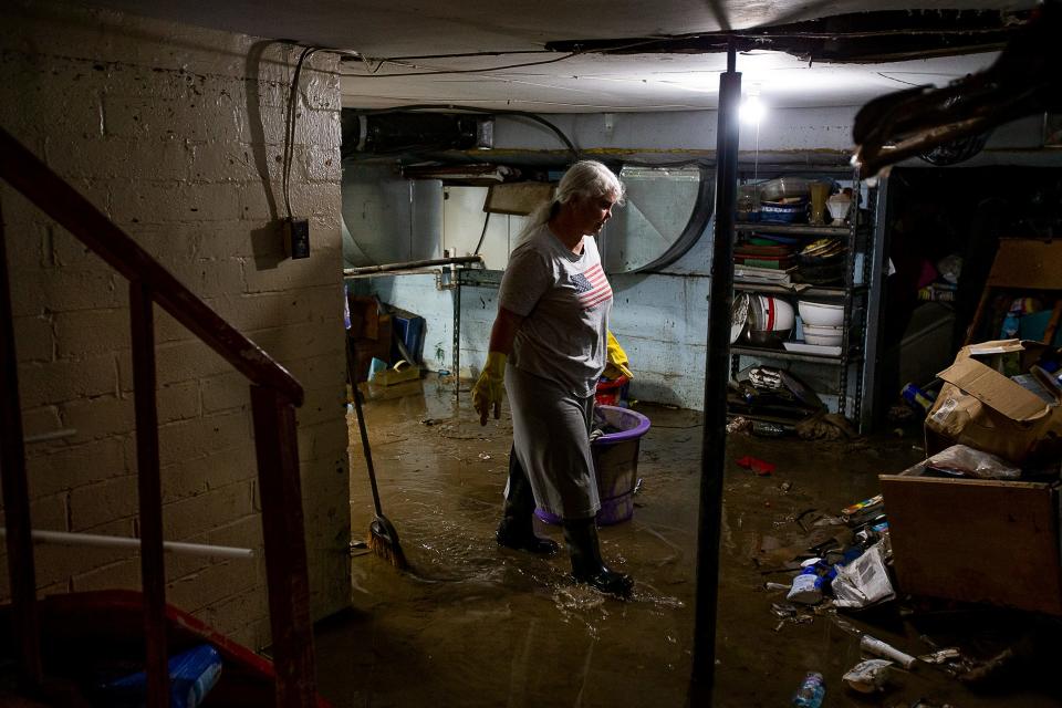 Libby Duty, 64, of Jenkins, Kentucky walks through the mud in her basement left behind from the retreating waters on Saturday, July 30, 2022, after historic rains flooded many areas of Eastern Kentucky. 