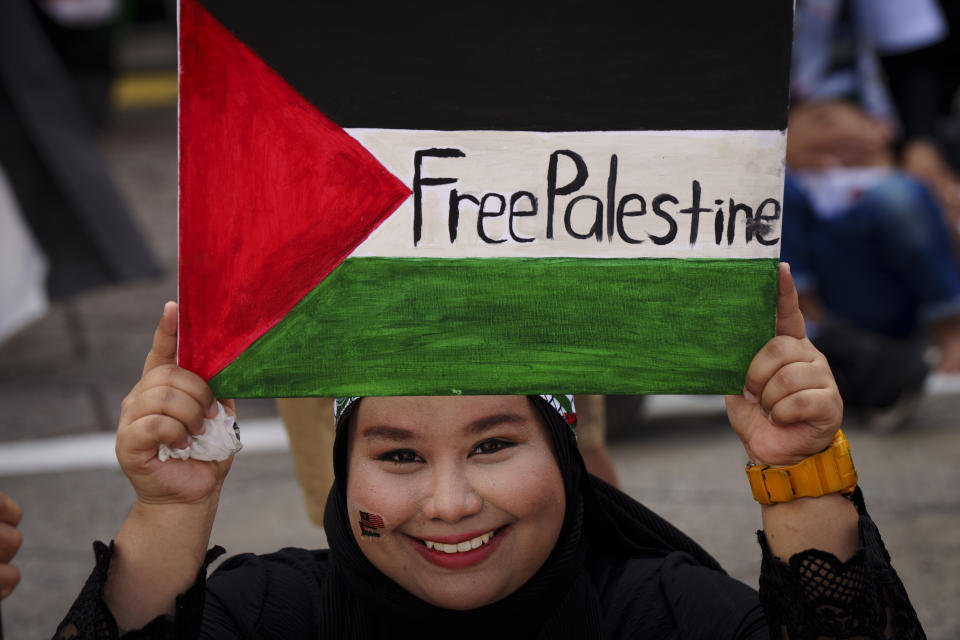 A Malaysian Muslim holds a poster representing the Palestinian flag during a rally to show her support for Palestinian people at Independence Square in Kuala Lumpur, Malaysia, Sunday, Oct. 22, 2023. (AP Photo/Vincent Thian)