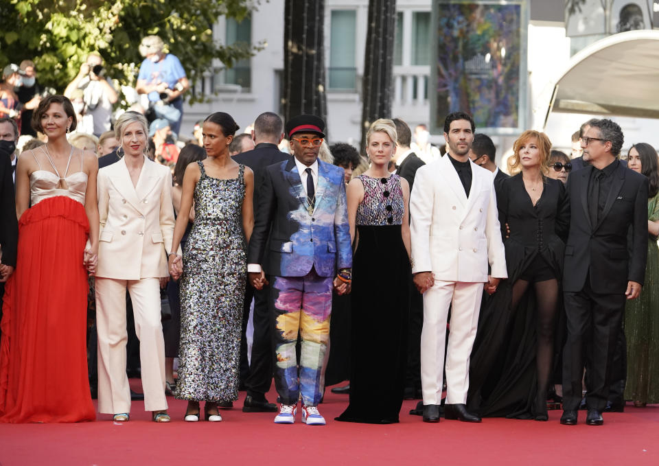 Jury members Maggie Gyllenhaal, from left, Jessica Hausner, Mati Diop, Spike Lee, Melanie Laurent,Tahar Rahim, Mylene Farmer, and Kleber Mendonca Filho poses for photographers upon arrival at the awards ceremony and premiere of the closing film 'OSS 117: From Africa with Love' at the 74th international film festival, Cannes, southern France, Saturday, July 17, 2021. (AP Photo/Brynn Anderson)