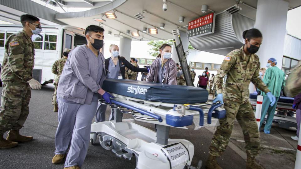 In this image provided by the U.S. Army, soldiers, airmen and civilian staff at Landstuhl Regional Medical Center, Germany, receive injured on Friday, Aug. 27, 2021, who were medically evacuated from Kabul, Afghanistan, after the bombing outside of Hamid Karzai International Airport in Kabul, Afghanistan, on Aug. 26. (Marcy Sanchez/U.S. Army via AP)