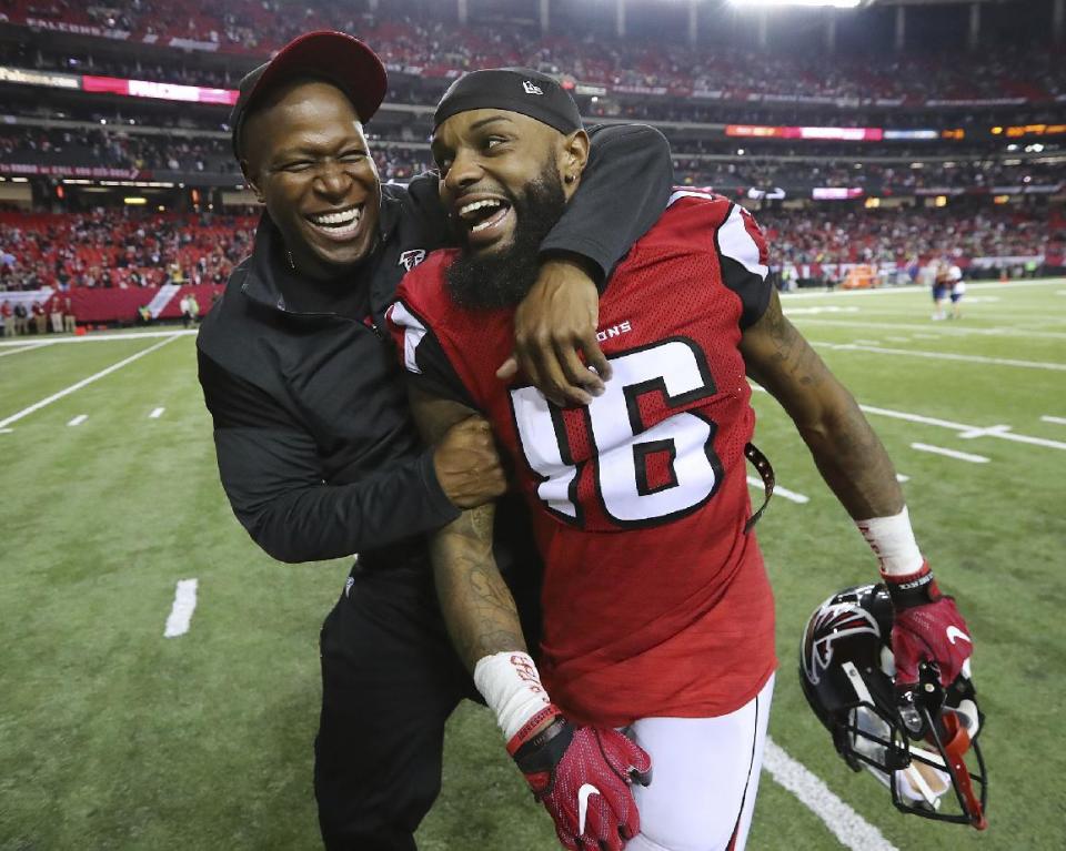 Atlanta Falcons wide receivers coach Raheem Morris and wide receiver Justin Hardy celebrate a 36-20 victory over the Seattle Seahawks in an NFL football NFC divisional playoff game on Saturday, Jan. 14, 2017, in Atlanta. (Curtis Compton/Atlanta Journal-Constitution via AP)