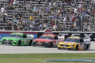 Kyle Busch (18), Denny Hamlin (11) and Chase Briscoe (14) race 3-wide during a NASCAR Cup Series auto race at Texas Motor Speedway Sunday, Oct. 17, 2021, in Fort Worth, Texas. (AP Photo/Larry Papke)