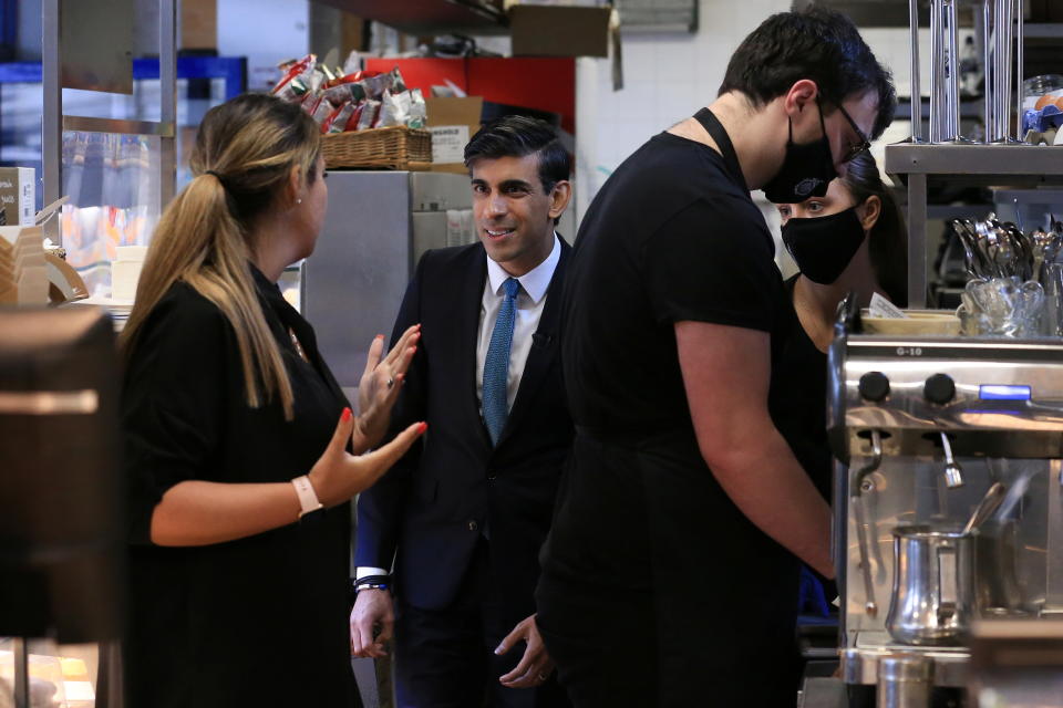 Britain's Chancellor of the Exchequer Rishi Sunak speaks to coffee shop staff during a visit to Bury Market in Lancashire, Britain October 28, 2021. Britain's pandemic-hit economy is set to extend its solid recovery into next year despite strong inflationary pressures, Sunak announced in his budget speech. Lindsey Parnaby/Pool via REUTERS