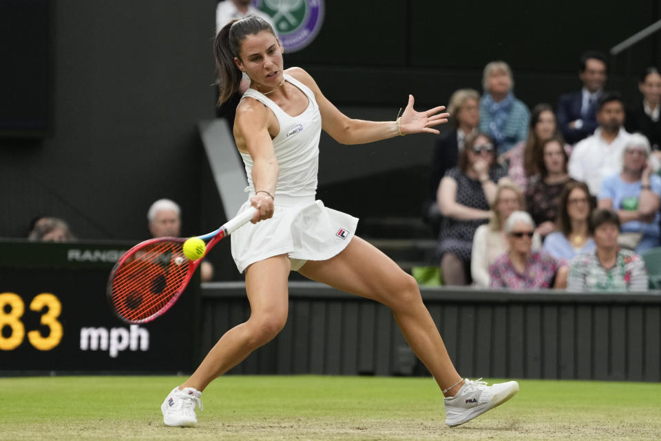 Emma Navarro of the United States plays a forehand return to Jasmine Paolini of Italy during their quarterfinal match at the Wimbledon tennis championships in London, Tuesday, July 9, 2024. (AP Photo/Alberto Pezzali)