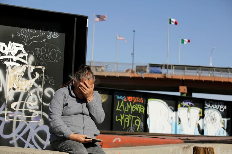 Guadalupe sits near the border fence between Mexico and U.S. where her son was shot in Ciudad Juarez