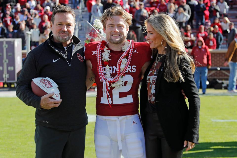 Oklahoma Sooners wide receiver Drake Stoops poses for a photo with his father, former Oklahoma coach Bob Stoops, and his mother, Carol Stoops, during Senior Day before a college football game between the University of Oklahoma Sooners (OU) and the TCU Horned Frogs at Gaylord Family-Oklahoma Memorial Stadium in Norman, Okla., Friday, Nov. 24, 2023. Oklahoma won 69-45.