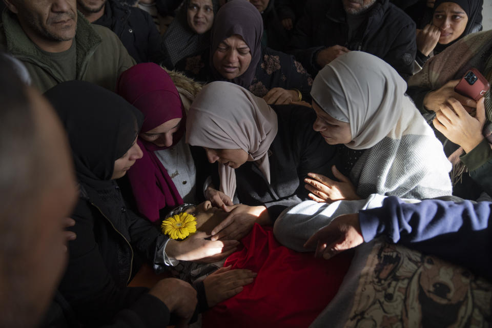 Mourners take the last look at the body of Palestinian Abdel Rahman Hamed, 18 during his funeral in the West Bank town of Silwad Monday, Jan. 29, 2024. Palestinian authorities say five Palestinians have been killed by Israeli forces in separate shootings across the occupied West Bank on Monday including Hamed who was killed during clashes with Israeli border police at his home village of Silwad. (AP Photo/Nasser Nasser)