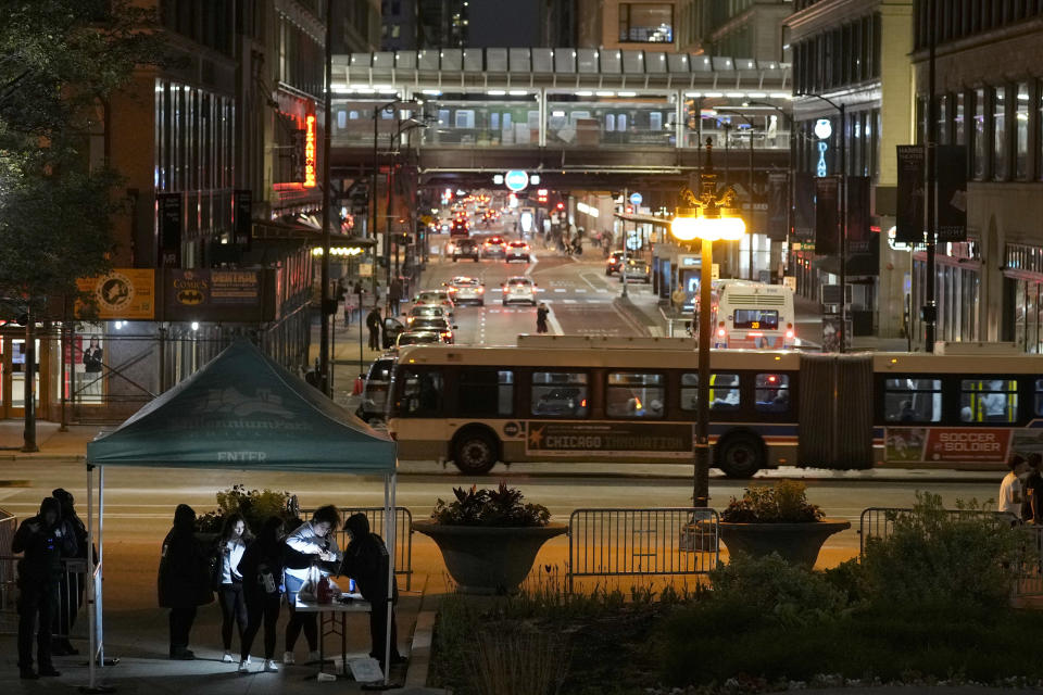 *Visitors to Chicago's Millennium Park are scanned for metal objects and have their bags checked by flashlight Thursday, May 25, 2023. Chicago is heading into the Memorial Day weekend hoping to head off violence that tends to surge with rising temperatures of summer. Even the state of Illinois is assisting by sending in what it's called "peacekeepers" in an attempt to deescalate violent situations. (AP Photo/Charles Rex Arbogast)