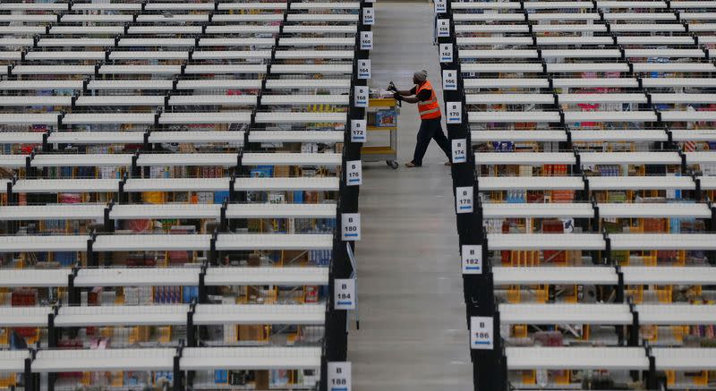 FILE PHOTO: A worker collects orders at Amazon's fulfilment centre in Rugeley, central England