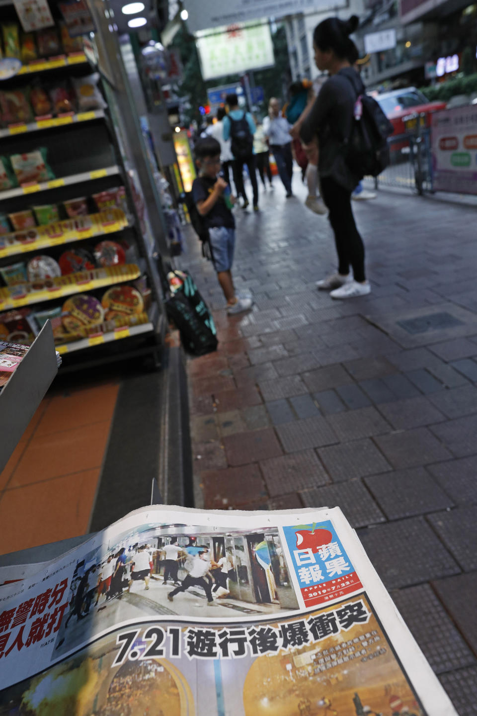 A newspaper front page shows a photo of white shirted thugs attacking commuters at a subway station in Hong Kong at a newsstand on Monday, July 22, 2019. China doesn't want to intervene in Hong Kong's protests but that doesn't mean it won't, as the movement enters its seventh week. (AP Photo/Vincent Yu)