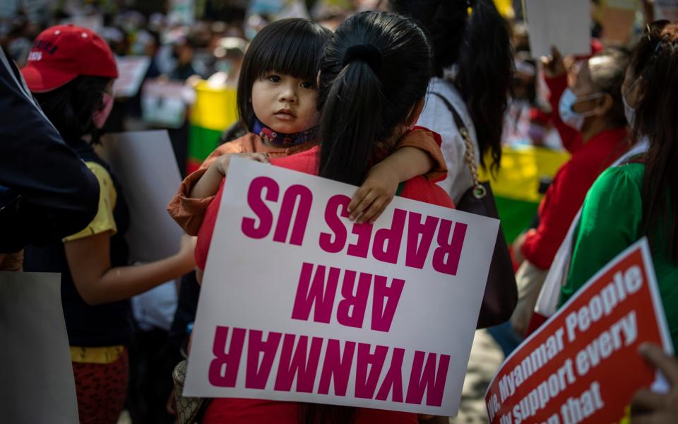 A young girl holds a placard as Chin refugees gather to participate in a protest - Altaf Qadri /AP