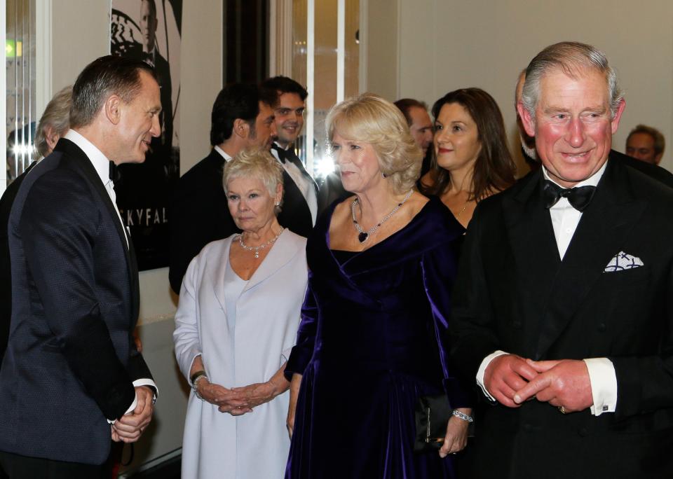 LONDON, UNITED KINGDOM - OCTOBER 23: Prince Charles, Prince of Wales (R) and Camilla, Duchess of Cornwall (2nd R) meet James Bond actors Daniel Craig (L) and Dame Judi Dench as they arrive for the Royal World Premiere of the James Bond film "Skyfall" at the Royal Albert Hall on October 23, 2012 in London, England. (Photo by Kirsty Wigglesworth - WPA Pool/Getty Images)