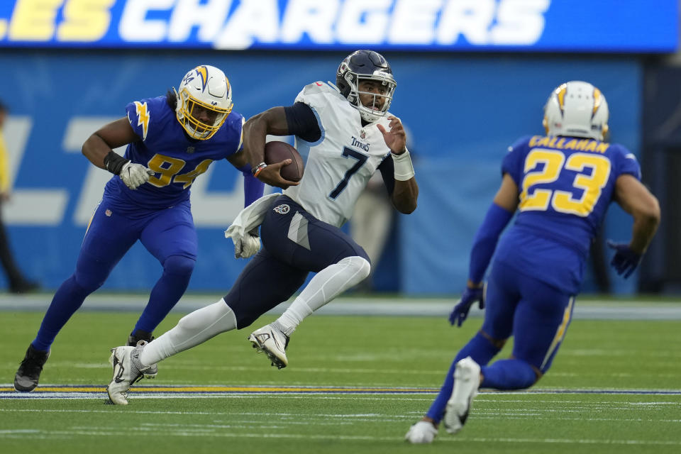 Tennessee Titans quarterback Malik Willis (7) runs against Los Angeles Chargers linebacker Chris Rumph II (94) and cornerback Bryce Callahan (23) during the first half of an NFL football game in Inglewood, Calif., Sunday, Dec. 18, 2022. (AP Photo/Marcio Jose Sanchez)