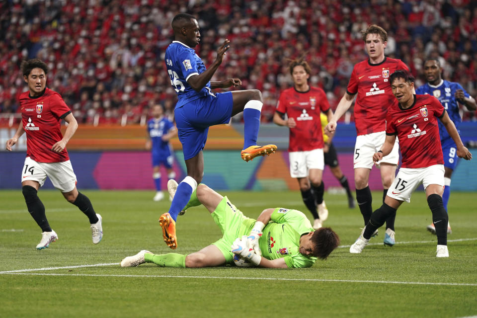 Saud Abdulhamid, top, of Saudi Arabia's Al Hilal, attempts to score a goal as the goalkeeper Shusaku Nishikawa of Japan's Urawa Red Diamonds, bottom, saves the goal, during the AFC Champions League final match between Japan's Urawa Red Diamonds and Saudi Arabia's Al Hilal at Saitama Stadium in Saitama, near Tokyo, Saturday, May 6, 2023. (AP Photo/Toru Hanai)