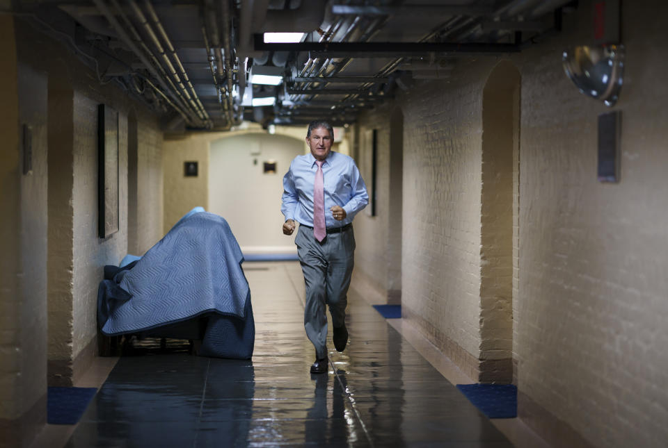 FILE - Sen. Joe Manchin, D-W.Va., one of the key Senate infrastructure negotiators, rushes back to a basement room at the Capitol as he and other Democrats work behind closed doors in Washington, June 16, 2021. (AP Photo/J. Scott Applewhite, File)