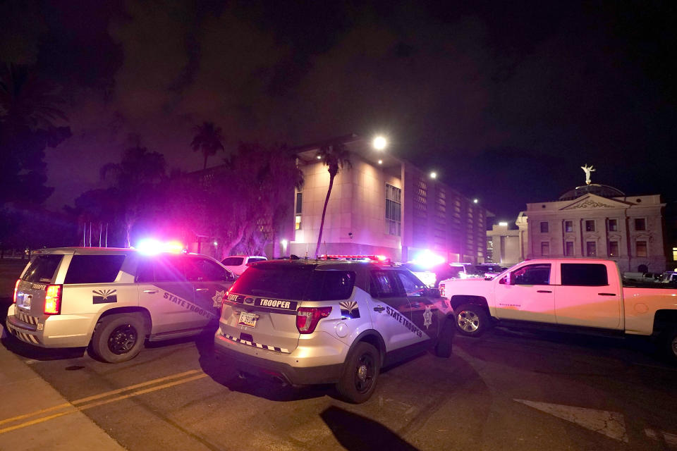 With tear gas in the air, a large number of police surround the Arizona Capitol after protesters reached the front of the AZ Senate building after the Supreme Court overturned the landmark Roe v. Wade abortion decision Friday, June 24, 2022, in Phoenix. (AP Photo/Ross D. Franklin)