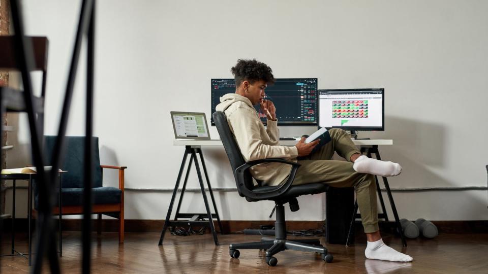 A student looks at a book at his desk.