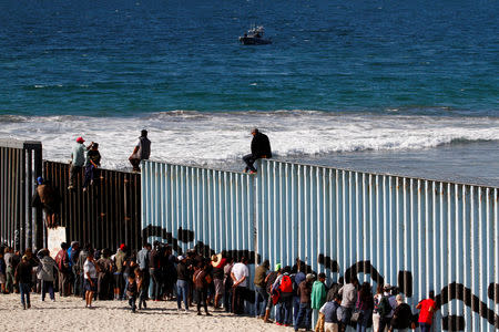 Migrants, part of a caravan of thousands trying to reach the U.S., look through the border fence between Mexico and the United States, in Tijuana, Mexico November 14, 2018. REUTERS/Jorge Duenes