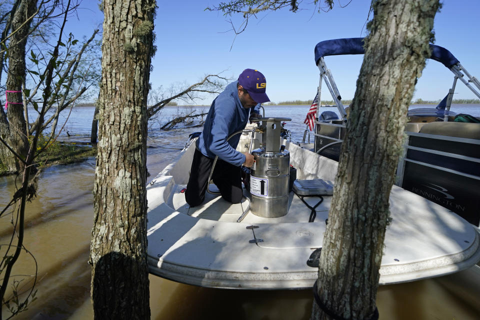 Andre Rabay, research scientist for the LSU Department of Oceanography and Coastal Science prepares a canister of liquid nitrogen that he will use to freeze samples of the ground on Mike Island, part of the Wax Lake Delta in the Atchafalaya Basin, in St. Mary Parish, La., Friday, April 2, 2021. NASA is using high-tech airborne systems along with boats and mud-slogging work on islands for a $15 million study of these two parts of Louisiana's river delta system. (AP Photo/Gerald Herbert)