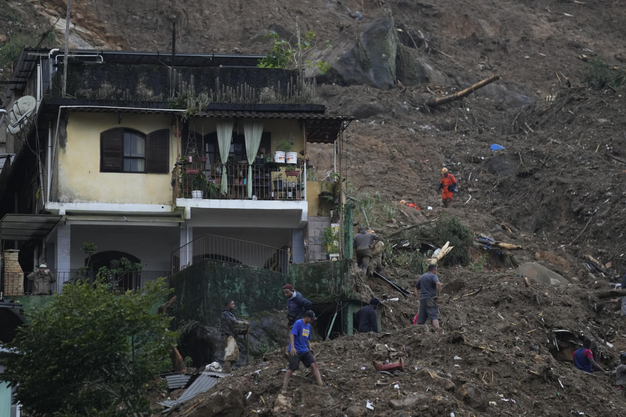 Rescue workers and residents search for victims in an area affected by landslides in Petropolis, Brazil, Wednesday, Feb. 16, 2022. Extremely heavy rains set off mudslides and floods in a mountainous region of Rio de Janeiro state, killing multiple people, authorities reported. (AP Photo/Silvia Izquierdo)