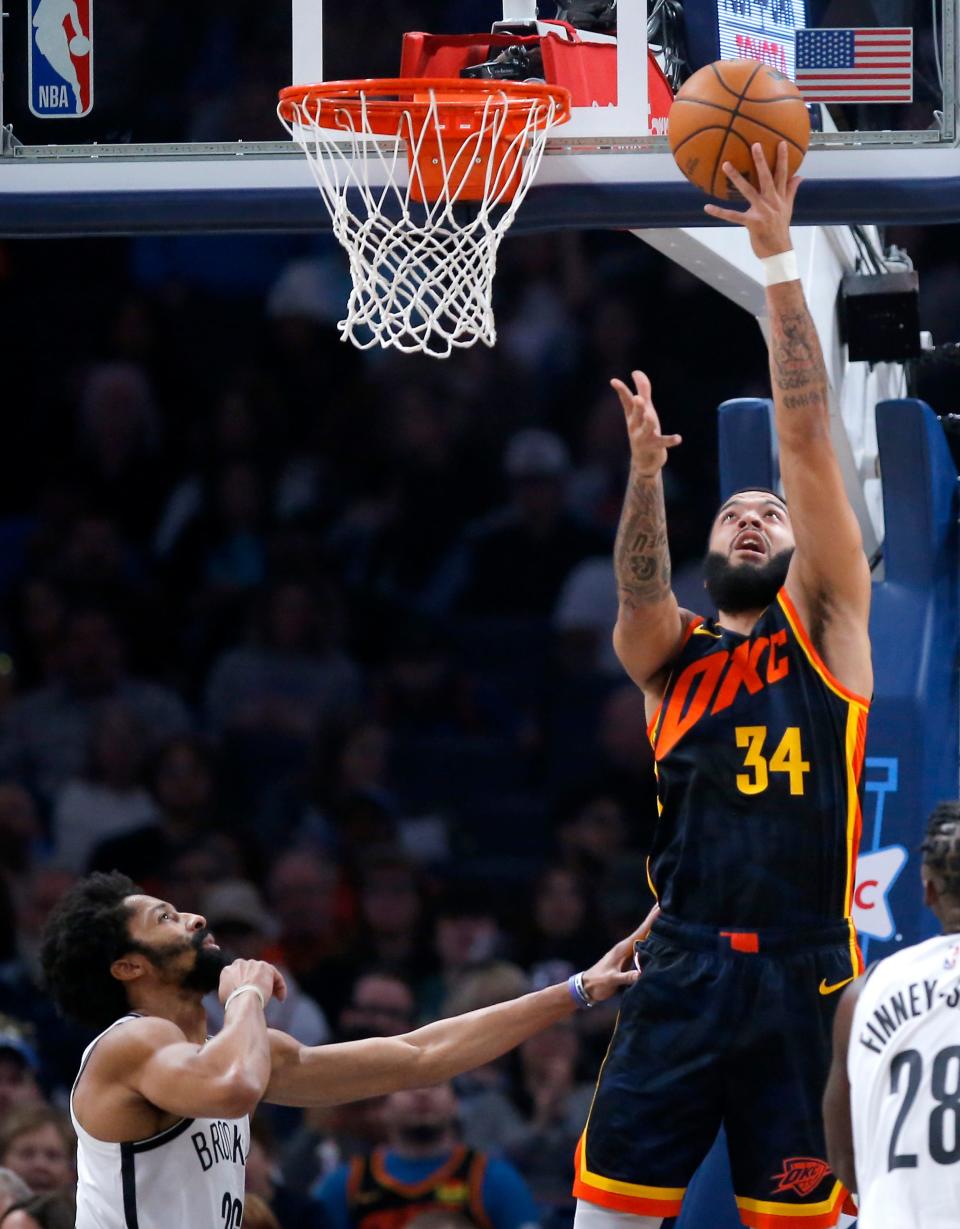 Oklahoma City Thunder forward Kenrich Williams (34) goes up for a basket next to Brooklyn Nets guard Spencer Dinwiddie (26) during the NBA basketball game between the Oklahoma City Thunder and the Brooklyn Nets at Paycom Center in Oklahoma City, Sunday, Dec. 31, 2023.