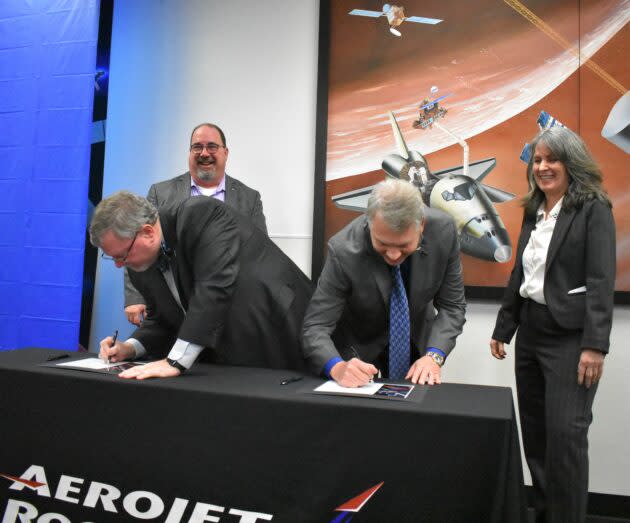 Lockheed Martin’s Mike Hawes and Scott Jones sign copies of a contract for Orion rocket hardware, after Aerojet Rocketdyne’s Ken Young and Cheryl Rehm take their turn. (GeekWire Photo / Alan Boyle)