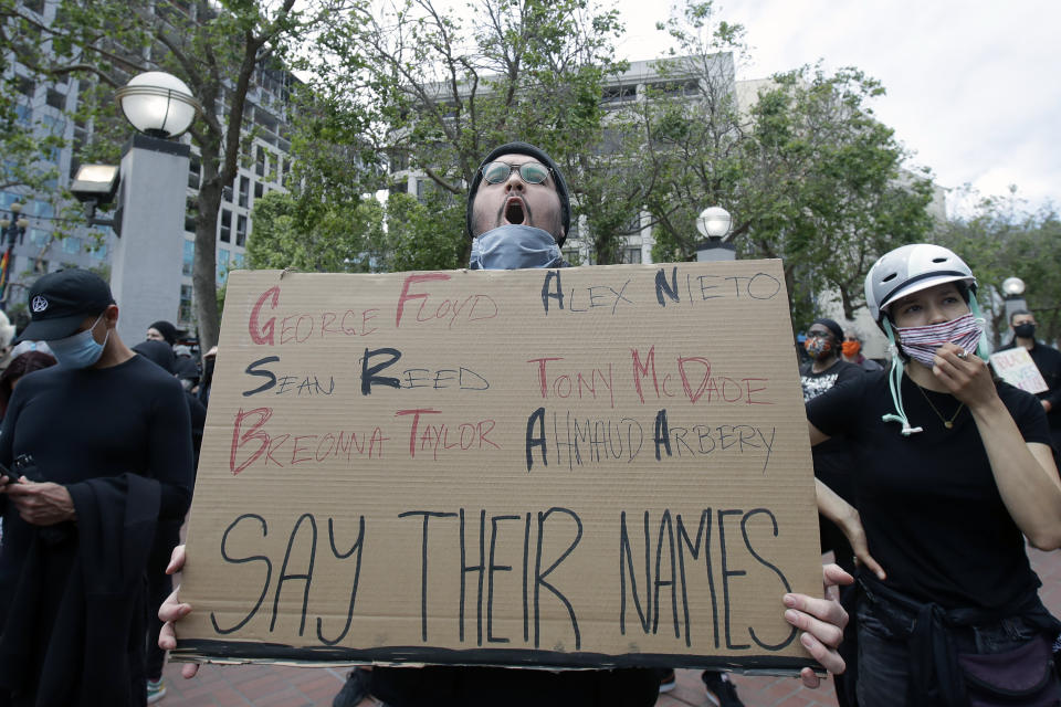 Nolan Ramirez holds up a sign at protest over the Memorial Day death of George Floyd, a handcuffed black man in police custody in Minneapolis, in San Francisco, Saturday, May 30, 2020. (AP Photo/Jeff Chiu)