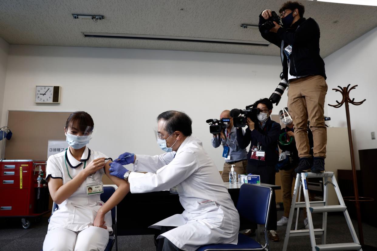 A medical worker receives a dose of the COVID-19 vaccine at Tokyo Medical Center in Tokyo on Wednesday, Feb. 17, 2021. J