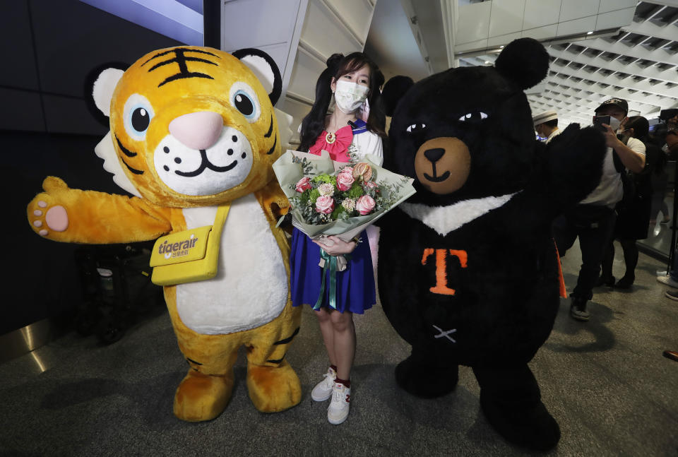 A foreign traveler poses for photos after arriving at Taoyuan International Airport in Taoyuan, Northern Taiwan, Thursday, Oct. 13, 2022. Taiwan announced that it will end mandatory COVID-19 quarantines for people arriving from overseas beginning Oct. 13. The Central Epidemic Command Center announced that the previous weeklong requirement will be replaced with a seven-day self-monitoring period. (AP Photo/Chiang Ying-ying)