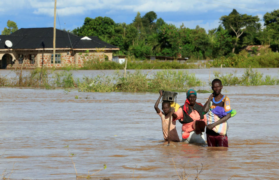 Residents wade through the waters after their home was flooded after the River Nzoia burst its banks and due to heavy rainfall and the backflow from Lake Victoria, in Budalangi within Busia County, Kenya May 3, 2020. REUTERS/Thomas Mukoya