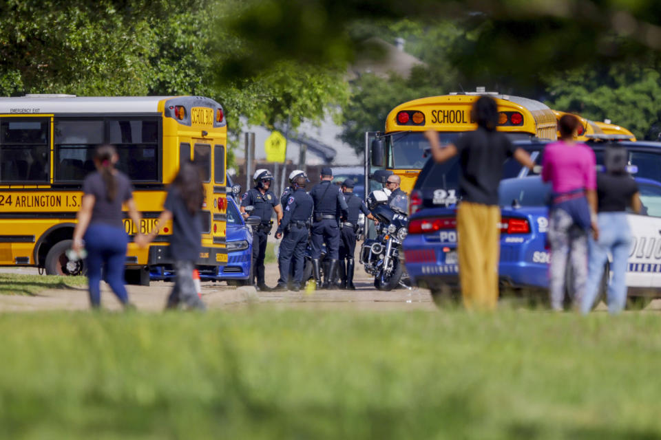 Onlookers wait outside Arlington Bowie High School after the school was placed on a lockdown due to a suspected shooting outside the school building, Wednesday April 24, 2024, in Arlington, Texas. (AP Photo/Gareth Patterson)