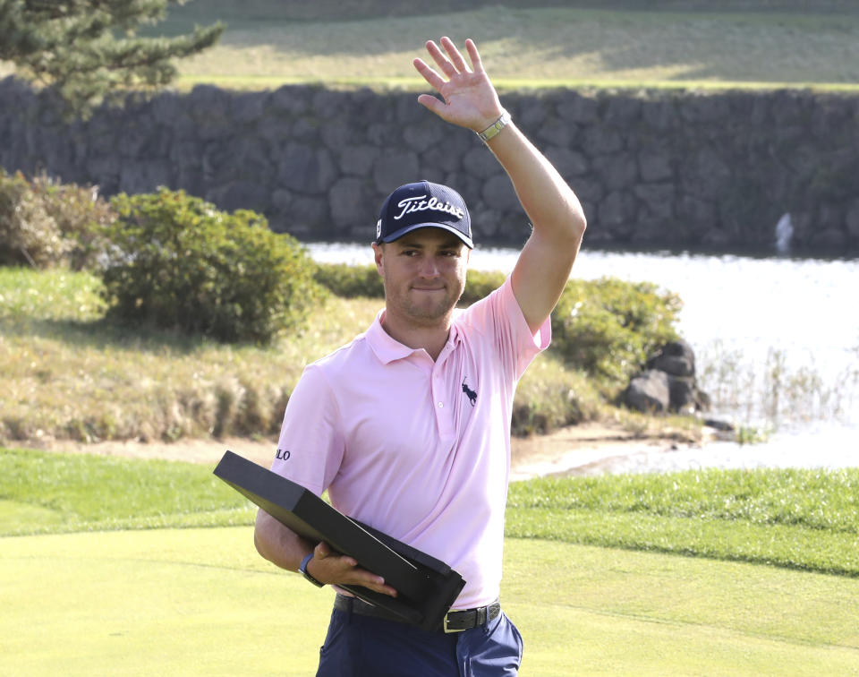 Justin Thomas of the United States waves with his trophy after winning the CJ Cup PGA golf tournament at Nine Bridges on Jeju Island, South Korea, Sunday, Oct. 20, 2019. (Chun Jin-hwan/Newsis via AP)