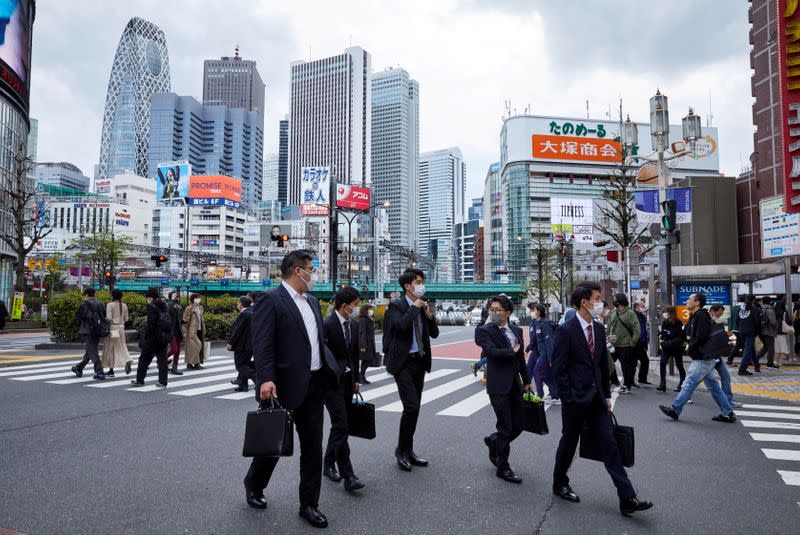 FILE PHOTO: Passersby walk on the street at Shinjuku district in Tokyo
