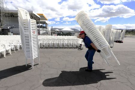 A Ecuadorean worker carries chairs in Par que Bicentenario where Pope Francis will give a mass during his upcoming visit to the country in Quito, Ecuador July 4, 2015. REUTERS/Jose Miguel Gomez