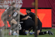 Canada's Samuel Adekugbe (3) is mobbed by teammates following his goal against the United States during the second half of a World Cup soccer qualifier in Hamilton, Ontario, Sunday, Jan. 30, 2022. (Frank Gunn/The Canadian Press via AP)