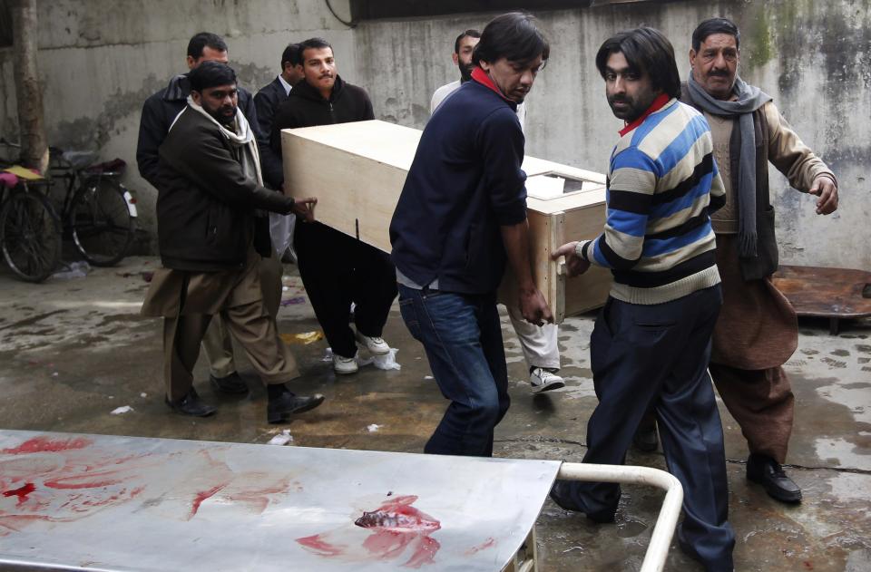 Relatives carry the casket of a victim who was killed in a bomb attack, at a hospital morgue in Rawalpindi