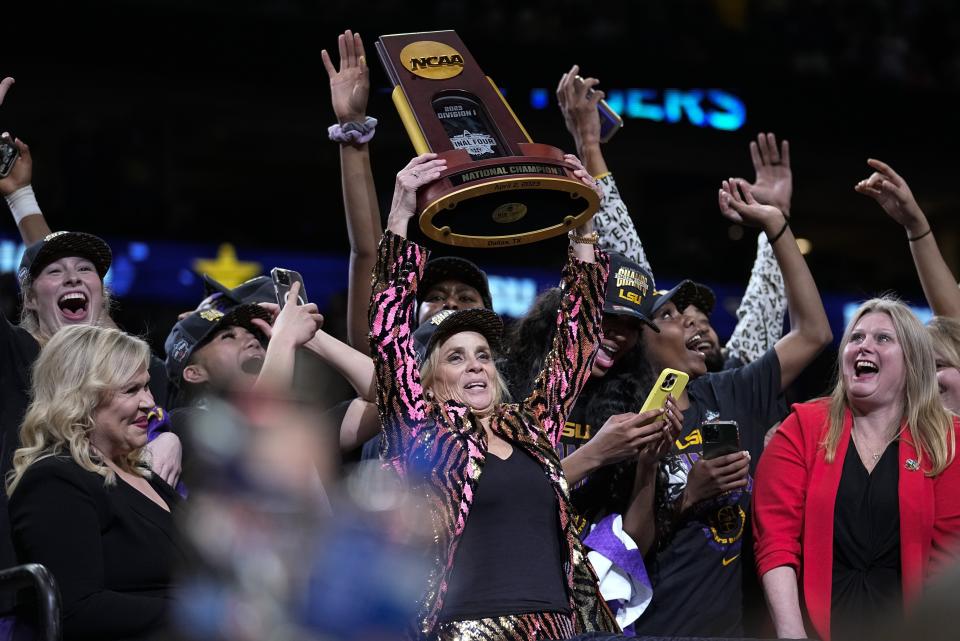 LSU head coach Kim Mulkey holds the winning trophy after the NCAA Women's Final Four championship basketball game against Iowa Sunday, April 2, 2023, in Dallas. LSU won 102-85 to win the championship. (AP Photo/Tony Gutierrez)