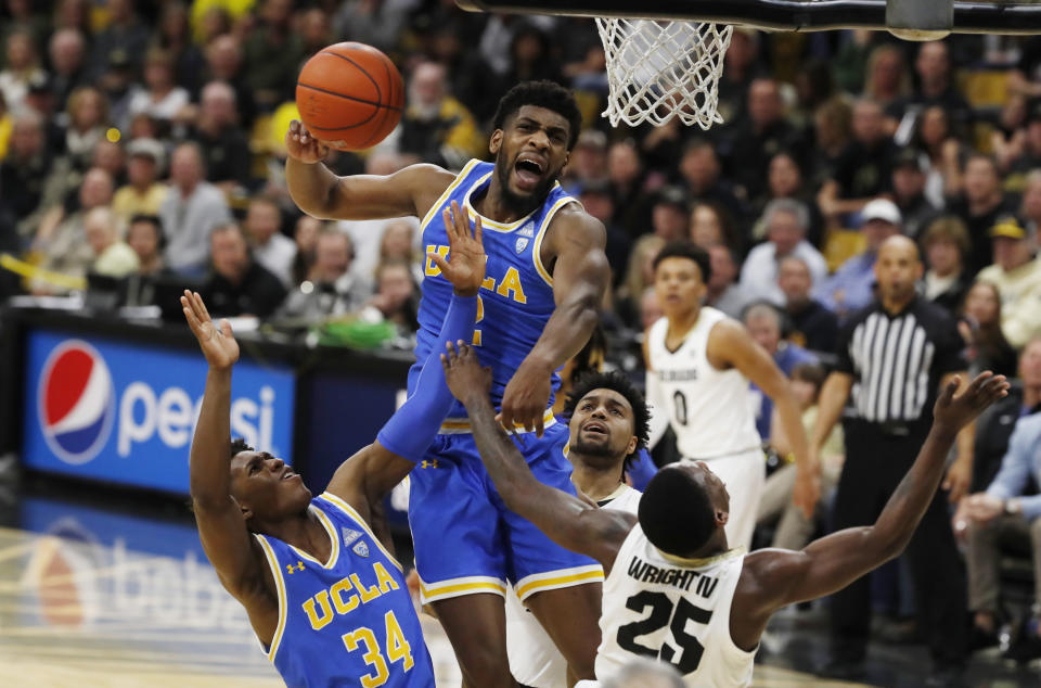 UCLA forward Cody Riley, center, blocks a shot by Colorado guard McKinley Wright IV, right, as UCLA guard David Singleton pulls in the loose ball in the second half of an NCAA college basketball game Saturday, Feb. 22, 2020, in Boulder, Colo. (AP Photo/David Zalubowski)sc