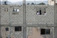 Jordanian brothers Hussein and Zeyad Ashish engage in an online boxing training on the roof of their home at Al-Baqaa Palestinian refugee camp, near Amman